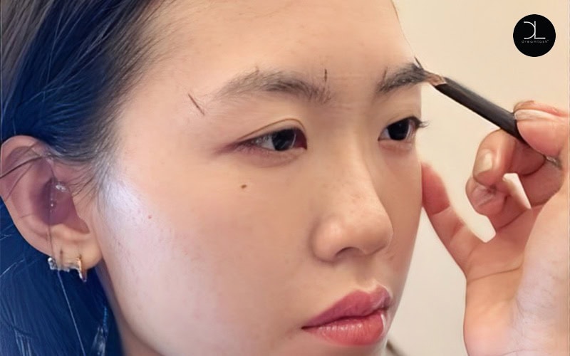 Beautician Doing Eyebrow Tattooing For Female Face